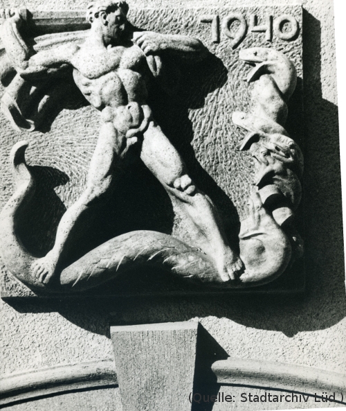 Foto: Steinrelief: Ein Männerakt mit Schwert kämpft gegen eine mehrköpfige Schlange.