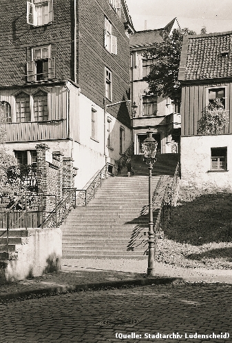 Foto: Von 1938: Eine breite, steile Freitreppe führt in die obere Stadt. Rechts und Links jeweils ein Haus. Vor der Treppe eine mit Gas betriebene Strassenlaterne.
