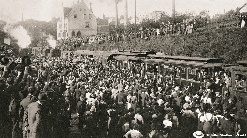 Foto: Ein Zug umringt von jubelnden Menschen